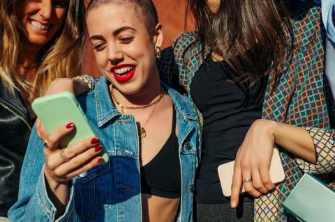 Femme regardant son téléphone en souriant